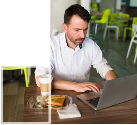 A professional working on a business management assignment at a laptop in a modern office space.