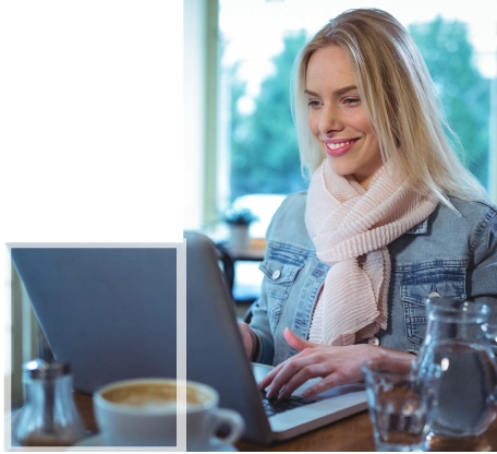 A student smiling while working on Human Resource Management academic assignments on a laptop.